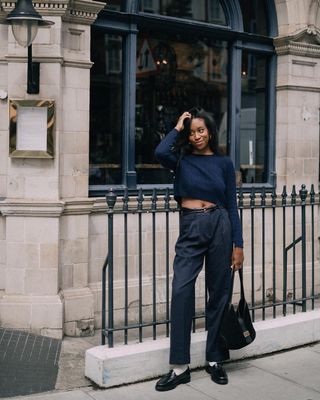 @chrissyford wearing navy trousers and jumper with black loafers