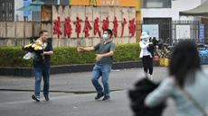 Workers in Zhuhai, China, remove flowers from memorial for mass killing