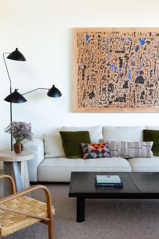 Small living room with grey sofa and and large artwork