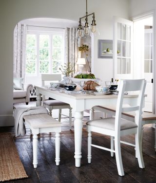 white dining table with white painted tables and chairs with brass bar pendant light