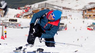 Man lying on snow ski crash injured knee in pain