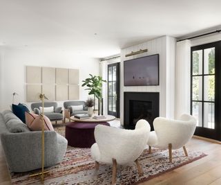 living room with two round coffee tables white walls artworks and wood floors with rug