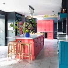 kitchen with pink and blue cabinets and island unit