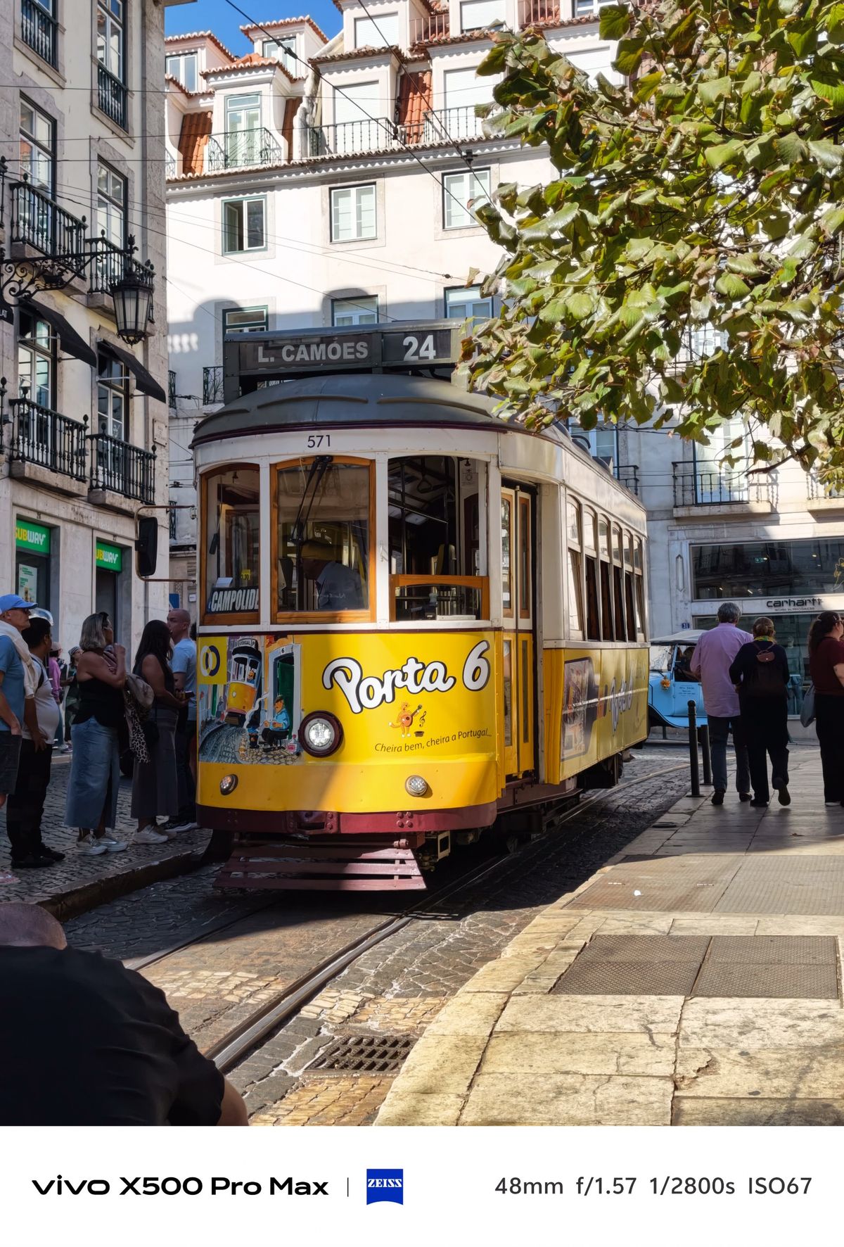 Yellow Lisbon tram marked route 24 traveling along a busy city street.