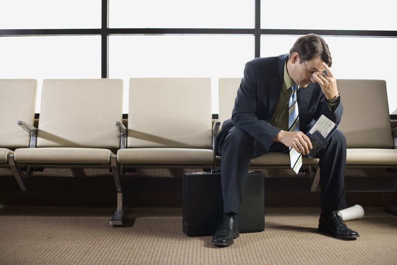 Stressed out businessman sitting in airport.