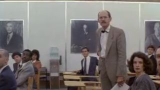 Frank Oz standing among test takers in Spies Like Us