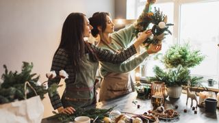 Two ladies put together a Christmas wreath