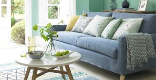 spearmint room with pale blue sofa to support common mistakes when buying a sofa