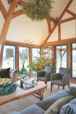 oak frame house sitting room with glazing on three sides decorated for christmas