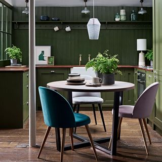 kitchen room with green timber wall and wooden worktop with wooden flooring and wooden table with chairs