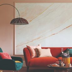 A pink-painted living room with a red sofa