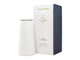 A conic diffuser by Aromatherapy Associates, made of ceramic, stands next to its white box against a white background.