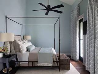 coastal style bedroom with four poster bed and light blue walls
