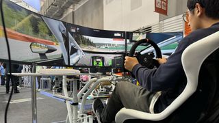 Man playing a racing game on Thermaltake GR500 Racing Sim Cockpit at Computex 2024.