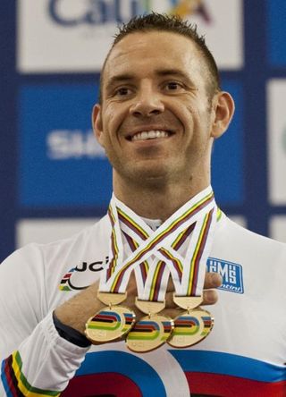 Francois Pervis holds his three gold medals won in Men's Sprint, Men's 1km Time Trial and Men's Keirin