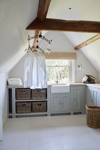 A utility room with beams and clean shirts hanging up to dry