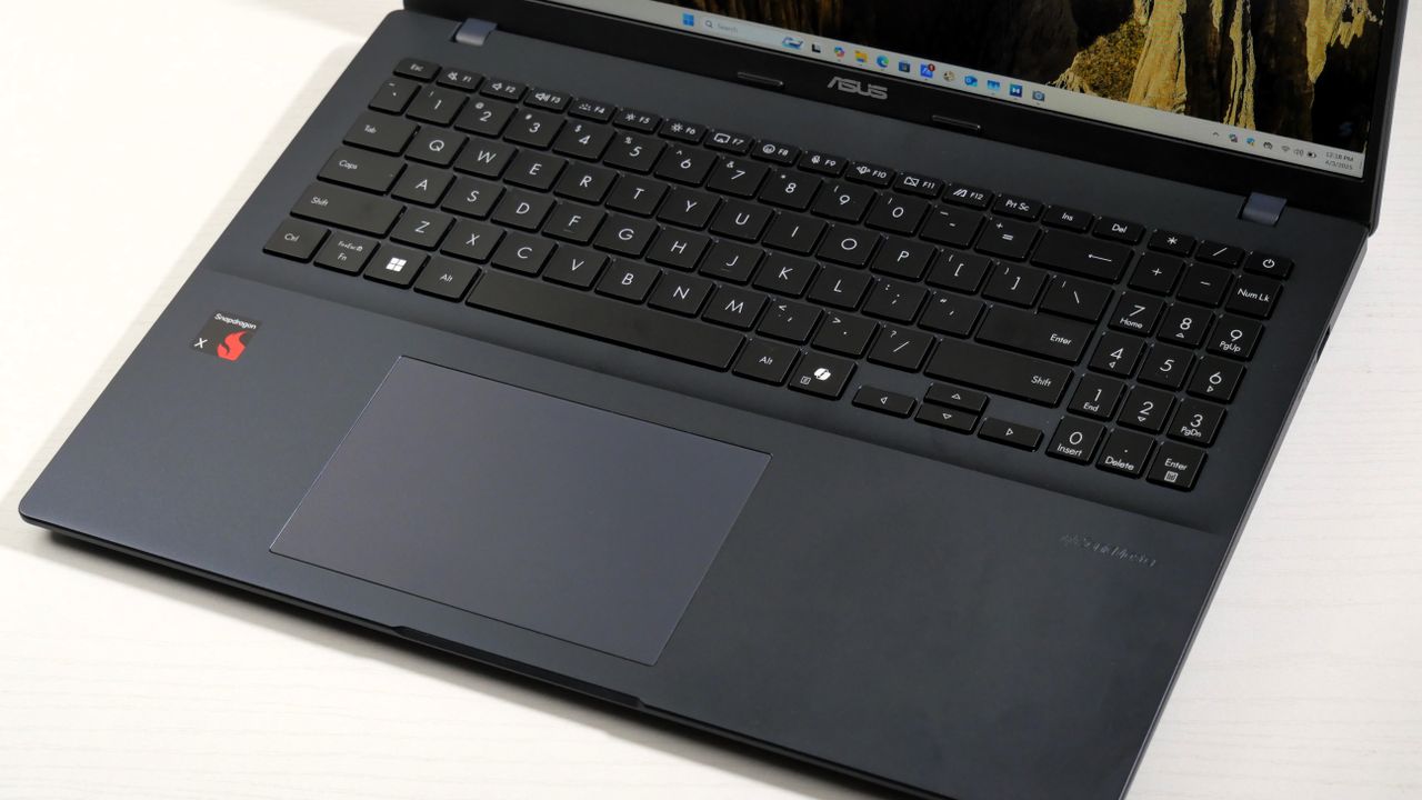 Asus Vivobook 16 (2025) open on a white table, highlighting the keyboard and trackpad.