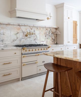 A neutral and marble kitchen with natural stone flooring