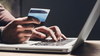 Man shopping online using laptop computer and credit card - stock photo