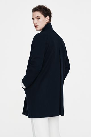 Rear view of black long jacket on female model