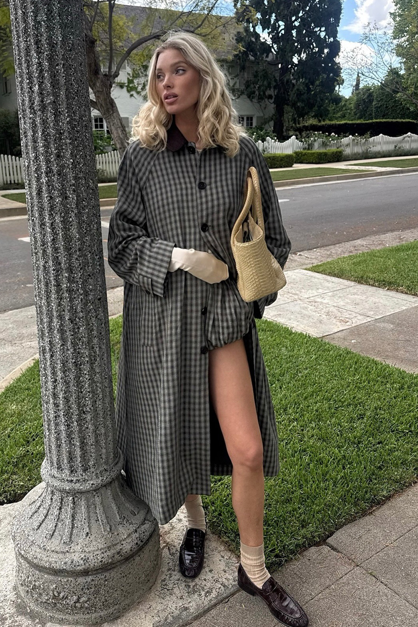 a woman wearing khaki socks and a plaid trench coat