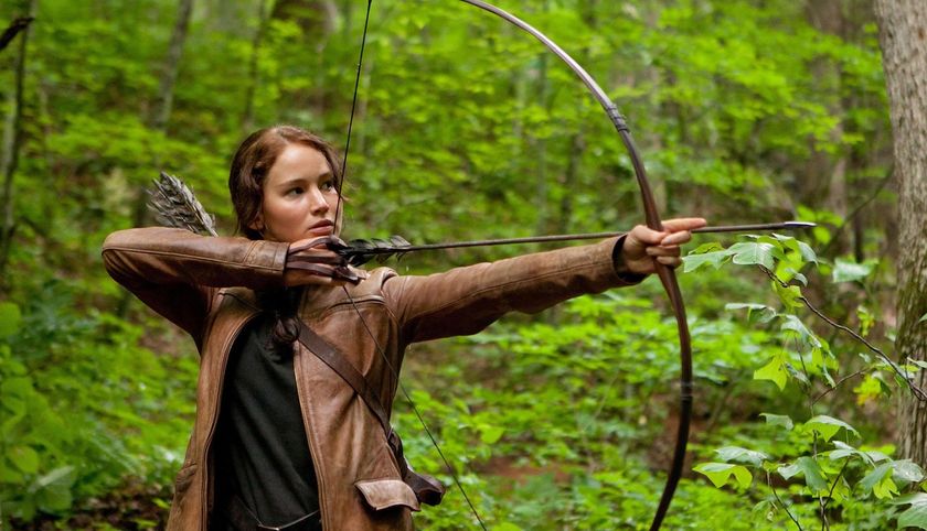 Jennifer Lawrence&#039;s Katniss Everdeen shooting an arrow in a forest in The Hunger Games