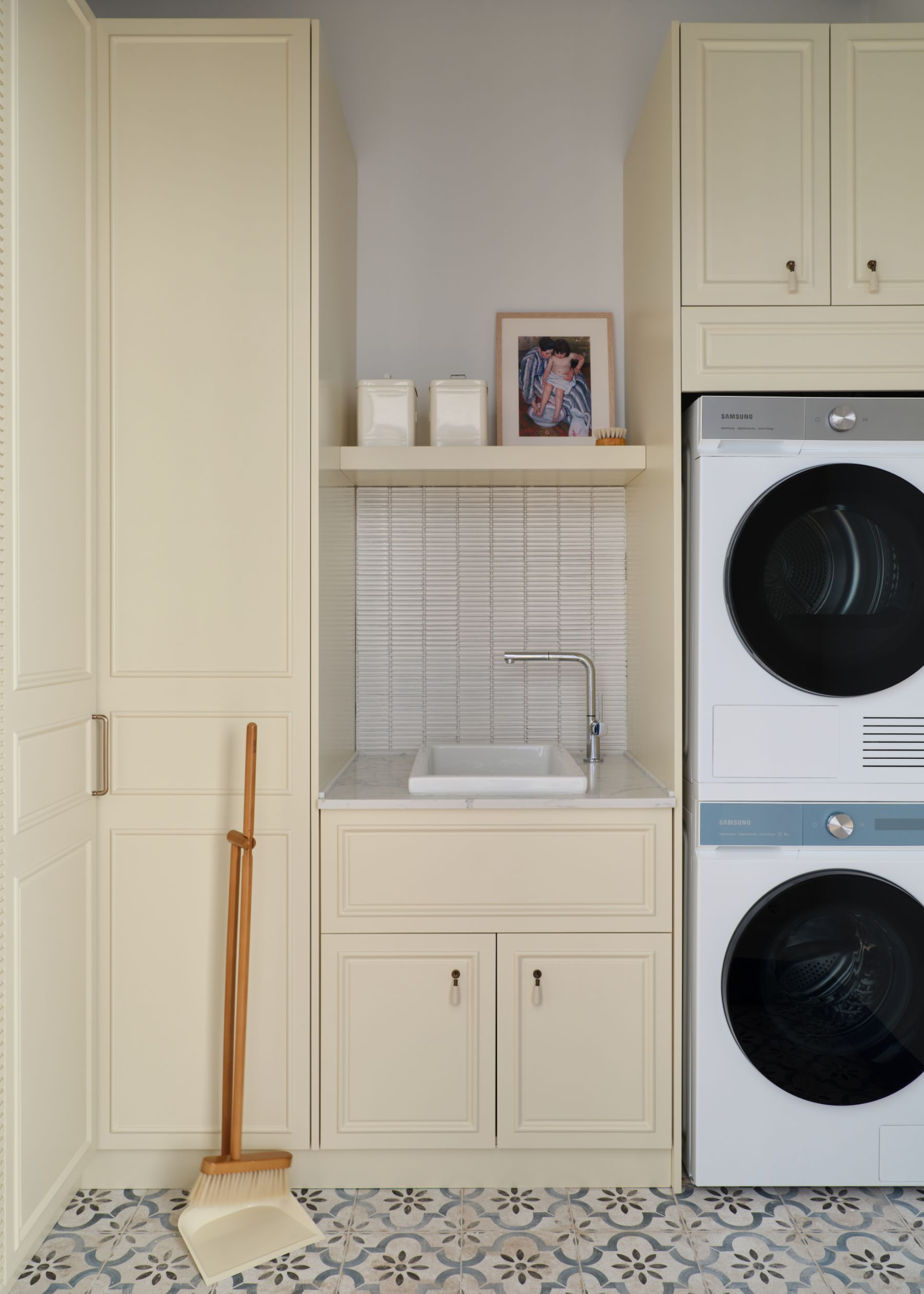 a pale butter yellow laundry room with tiled floors as well as a washer and drying on the side