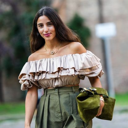 Best bright lipsticks - Bettina Looney wears a gold chain with a large heart pendant necklace, a gold necklace, a baige ruffled shoulder-off / puffy sleeves cropped t-shirt, khaki high waist oversized midi pants, a gold watch, a gold bracelet, a dark green / khaki velvet handbag, - getty images 1342003854