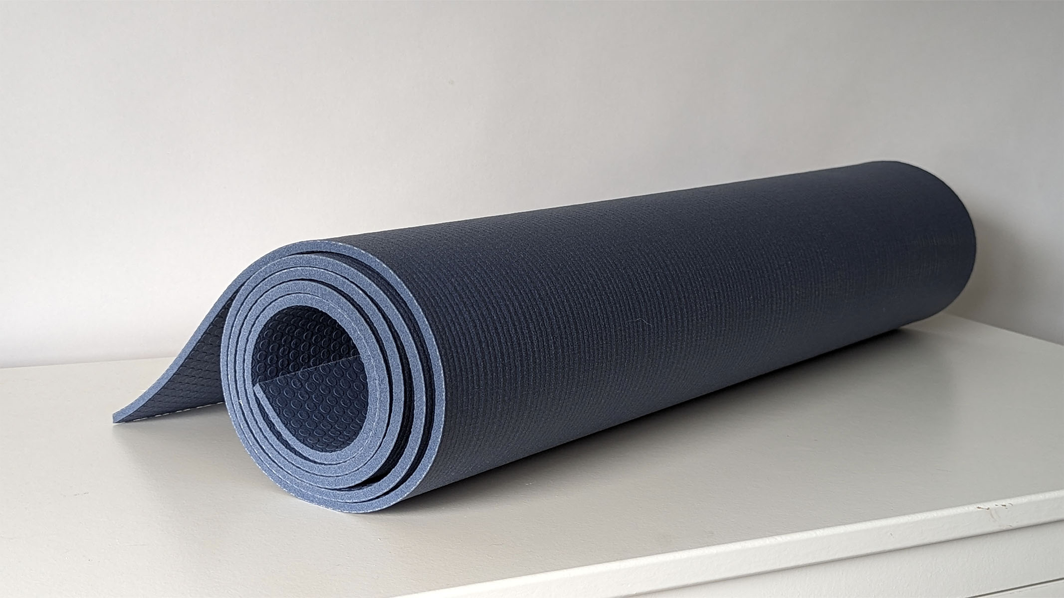 Manduka PRO yoga mat placed carefully on a white table