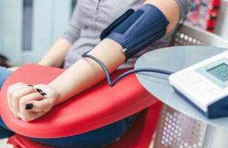 A person taking her blood pressure.