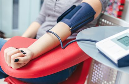 A person taking her blood pressure.