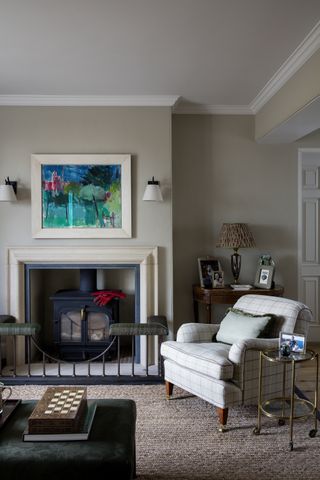 living room with fireplace and white armchair alongside artwork and wall lights