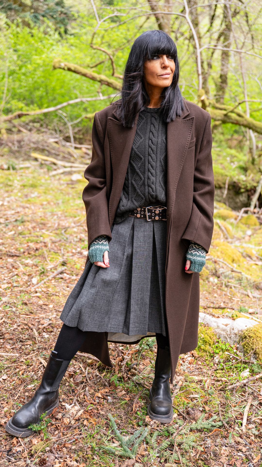 Claudia Winkleman wearing a brown coat and kilt skirt on The Celebrity Traitors