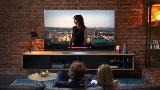 Menschen, die einen LG OLED-Fernseher in ihrem Wohnzimmer genießen