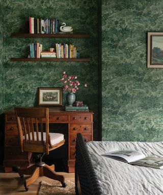 wallpapered guest bedroom with a small antique desk for working from home