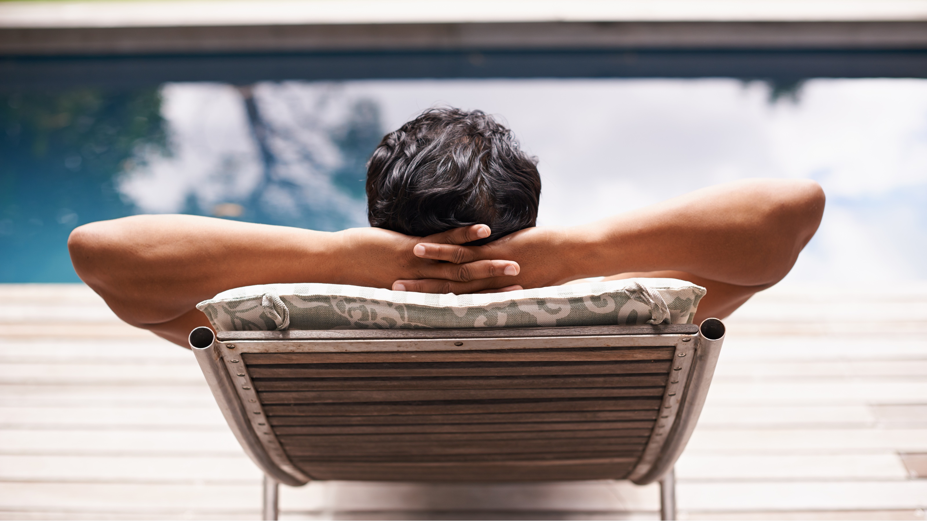 A man relaxes at poolside.