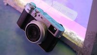 Fujifilm X100VI camera in front of a purple neon light