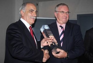 Juan Carlos Castaño Moreta receives the UCI's trophy for top team in the 2009 World Rankings from UCI president Pat McQuaid (R)