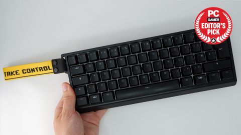 Wooting 60HE gaming keyboard pictured with yellow wrist strap attached.