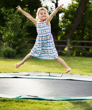 girl bouncing on an in-ground trampoline