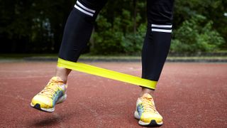 Close up of person&#039;s feet while they use a resistance band to train