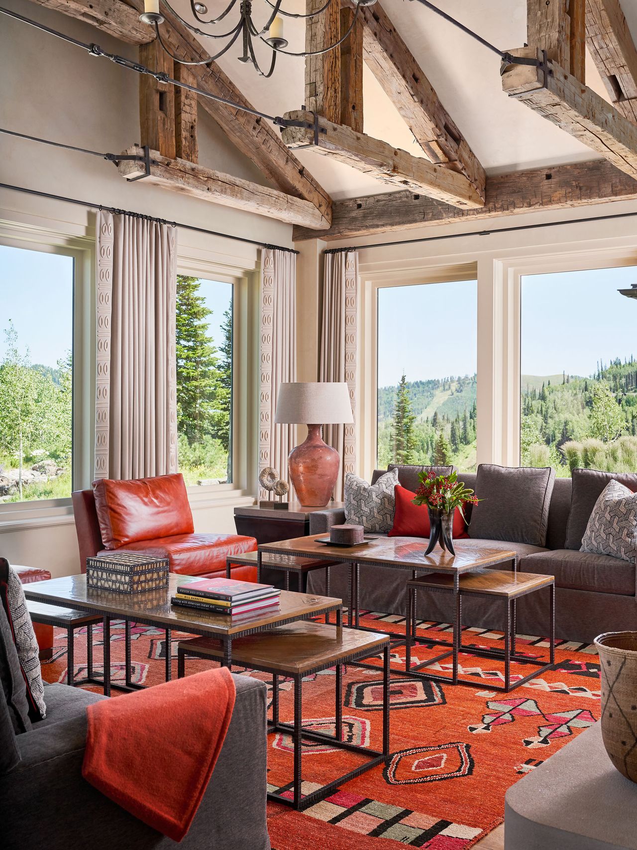 Orange pattern rug, red leather chair and cushion, layered wooden tables