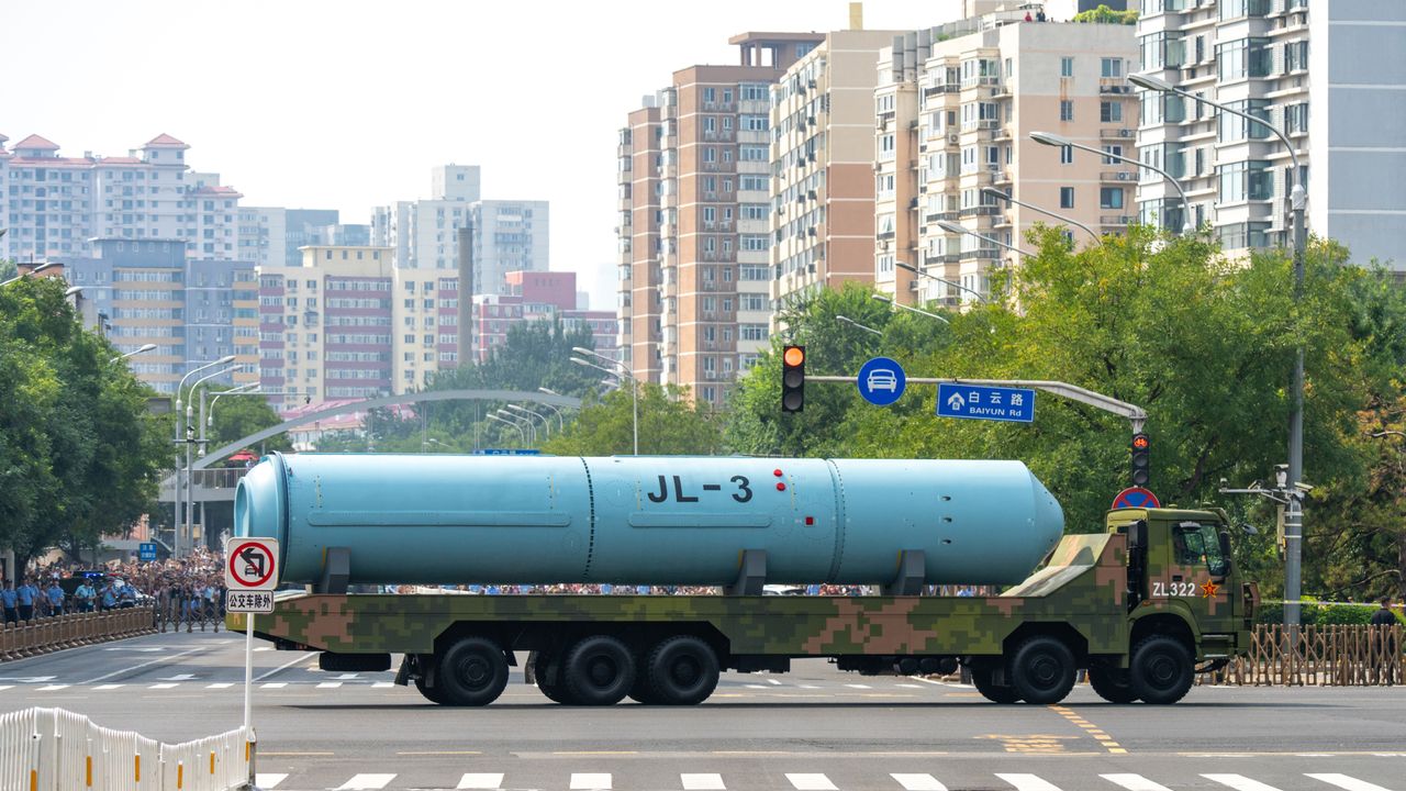 A large ICBM is showcased on the back of a truck as part of a military parade in China as the truck moves through an intersection