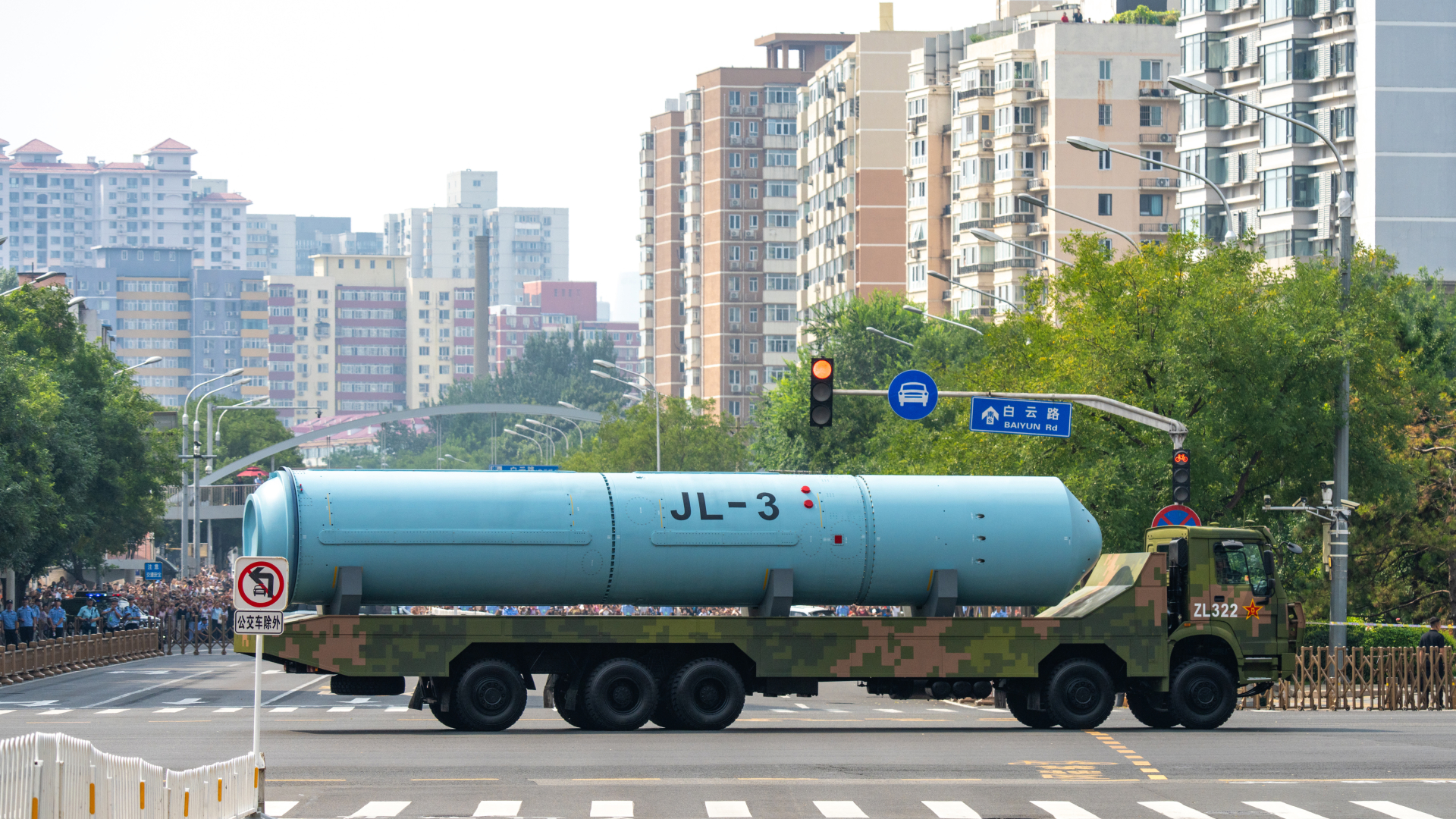 A large ICBM is showcased on the back of a truck as part of a military parade in China as the truck moves through an intersection