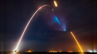 a rocket launch leaves a streak of light in the night sky