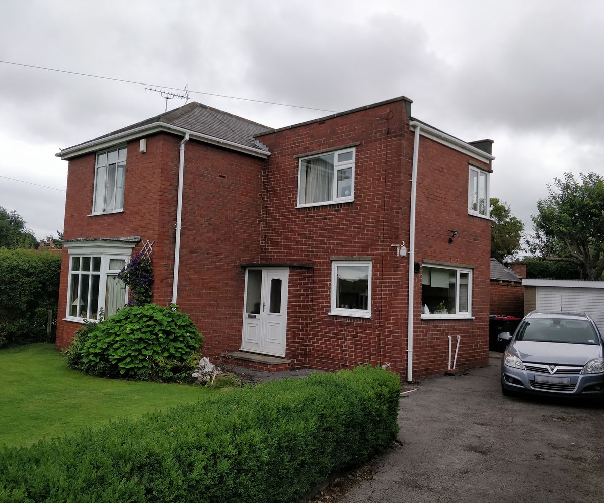The before image of a house which is about to be renovated and extended the exterior is red brick and it's a two storey home