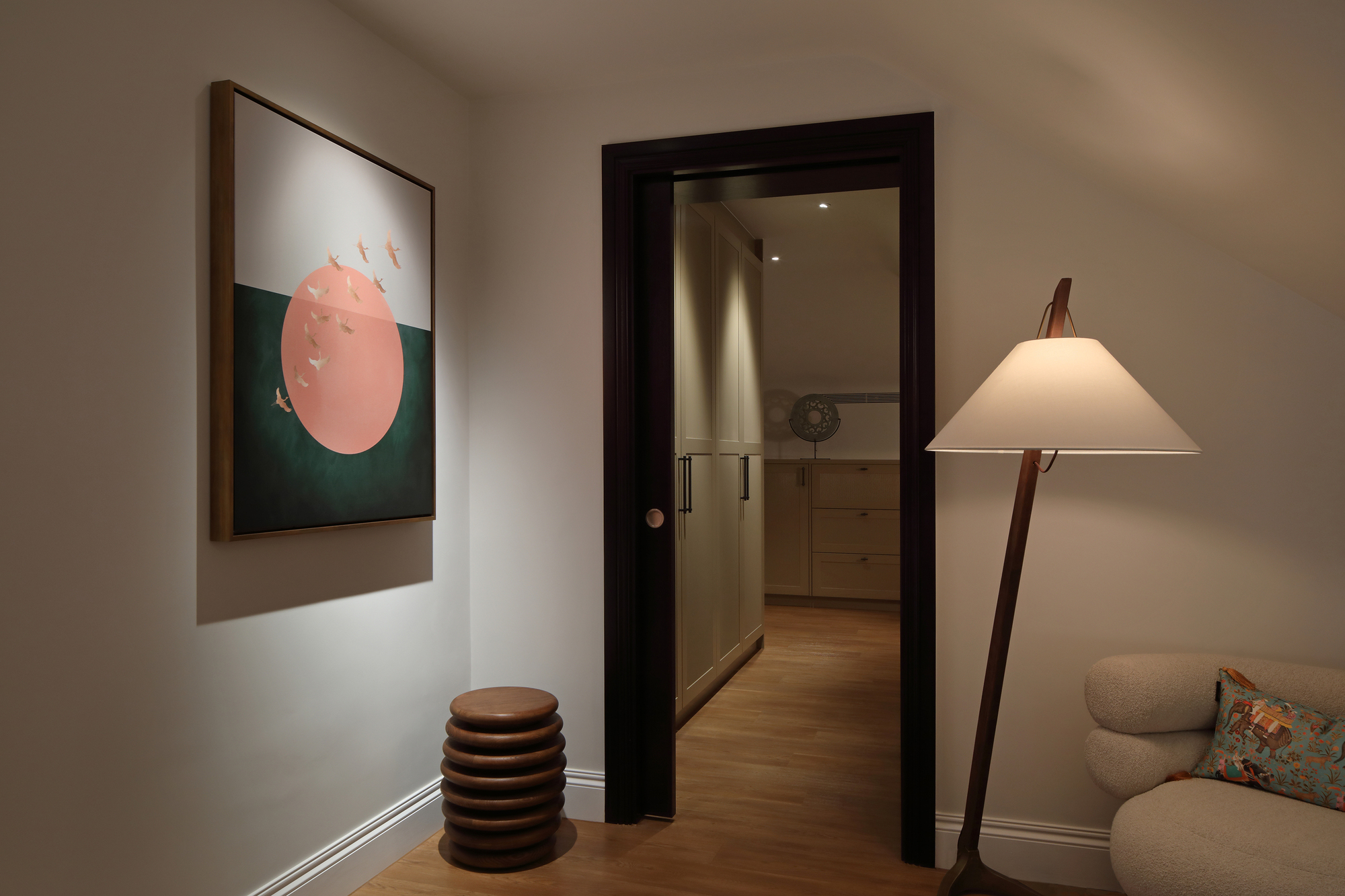 A living area with spotlights used to accentuate abstract artwork on the walls