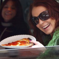 Woman holding up slice of pizza
