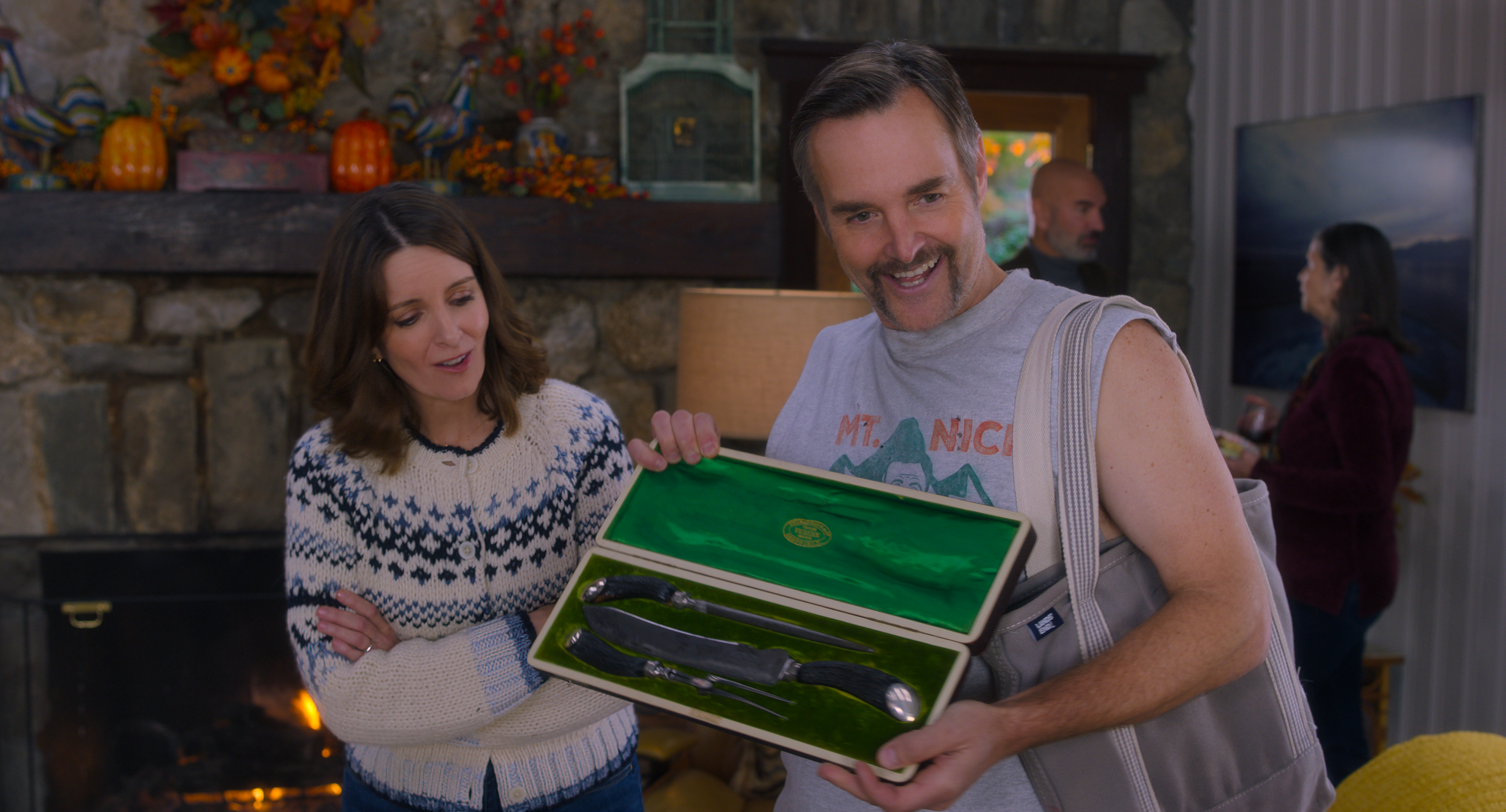 tina Fey as Kate and Will Forte as Jack looking at a knife in a fall decorated cabin in a still from the four seasons season 2