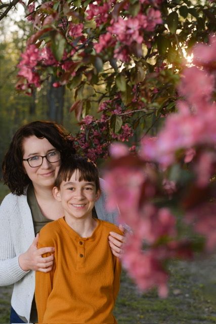 A mom with her child under a blossoming cherry tree